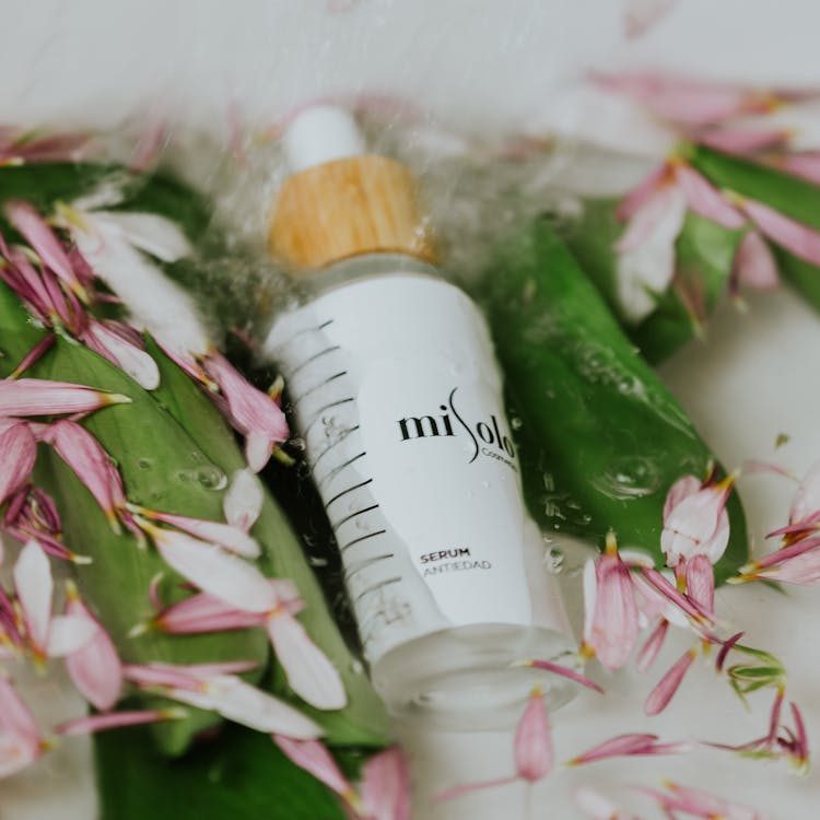 Close-up Of Cosmetics Bottle In Flower Bath