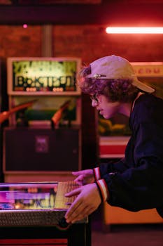 Teenager enjoying a game of pinball in a vibrant, retro-themed arcade.