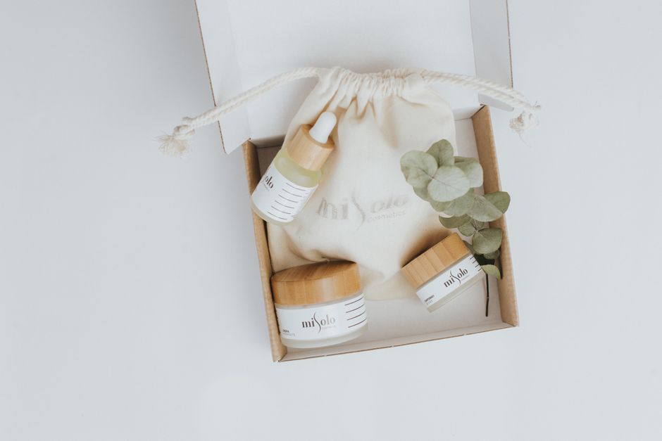 A flat lay of eco-friendly cosmetics including serum and cream in sustainable packaging.