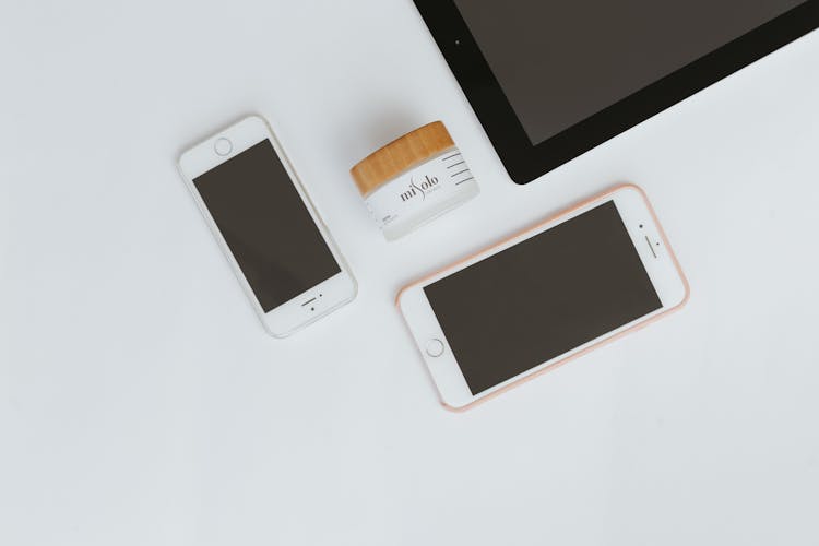 Smartphones Next To Beauty Product On Table