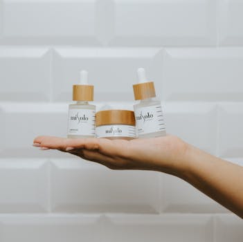 Three luxury skincare products showcased on an open hand against a minimalist background.