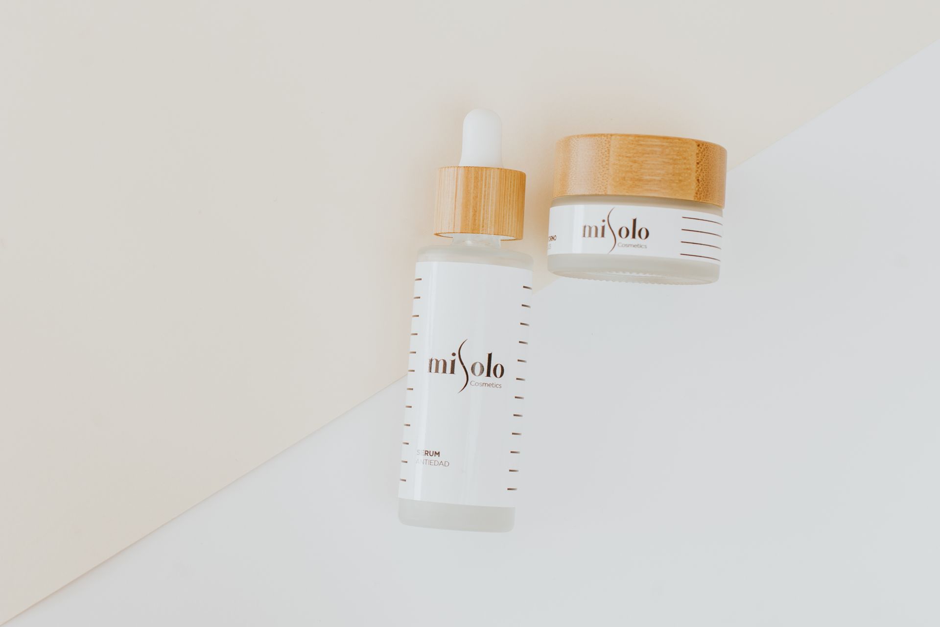 Minimalist flat lay of skincare products with bamboo lids on a neutral background.