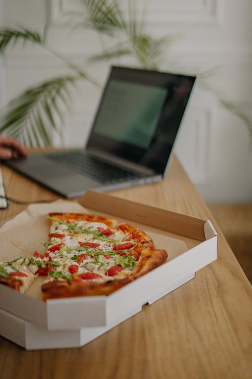 Free Close-Up Shot of a Box of Pizza on a Wooden Table Stock Photo