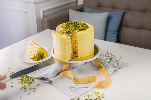 Delicious yellow cake topped with pistachios, beautifully sliced and served with floral decoration.
