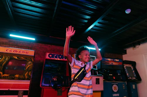 Woman in Orange and White Stripe Jersey Shirt Raising Her Hands