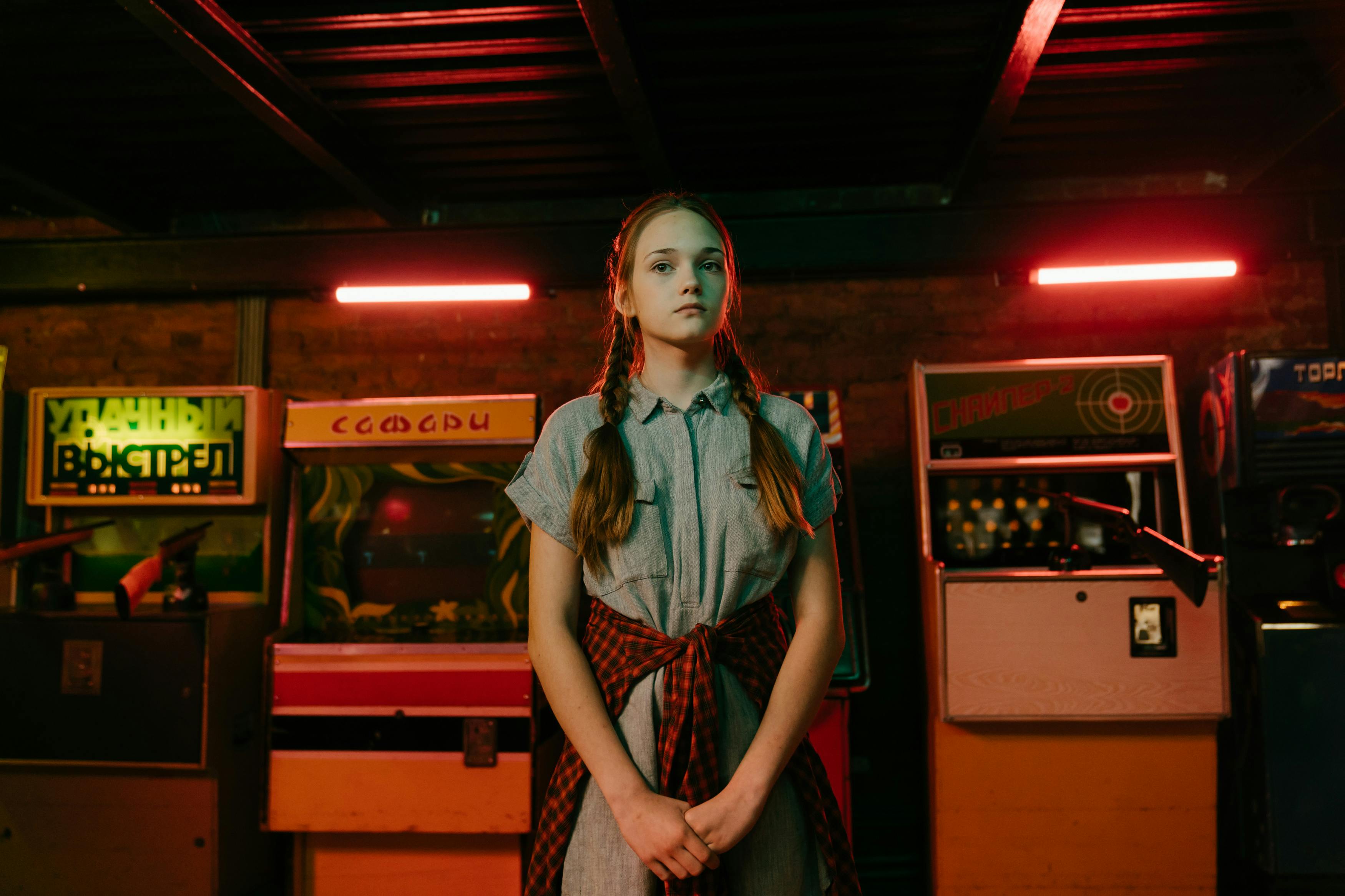Woman in Green and Red Dress Standing Near Red Wooden Counter