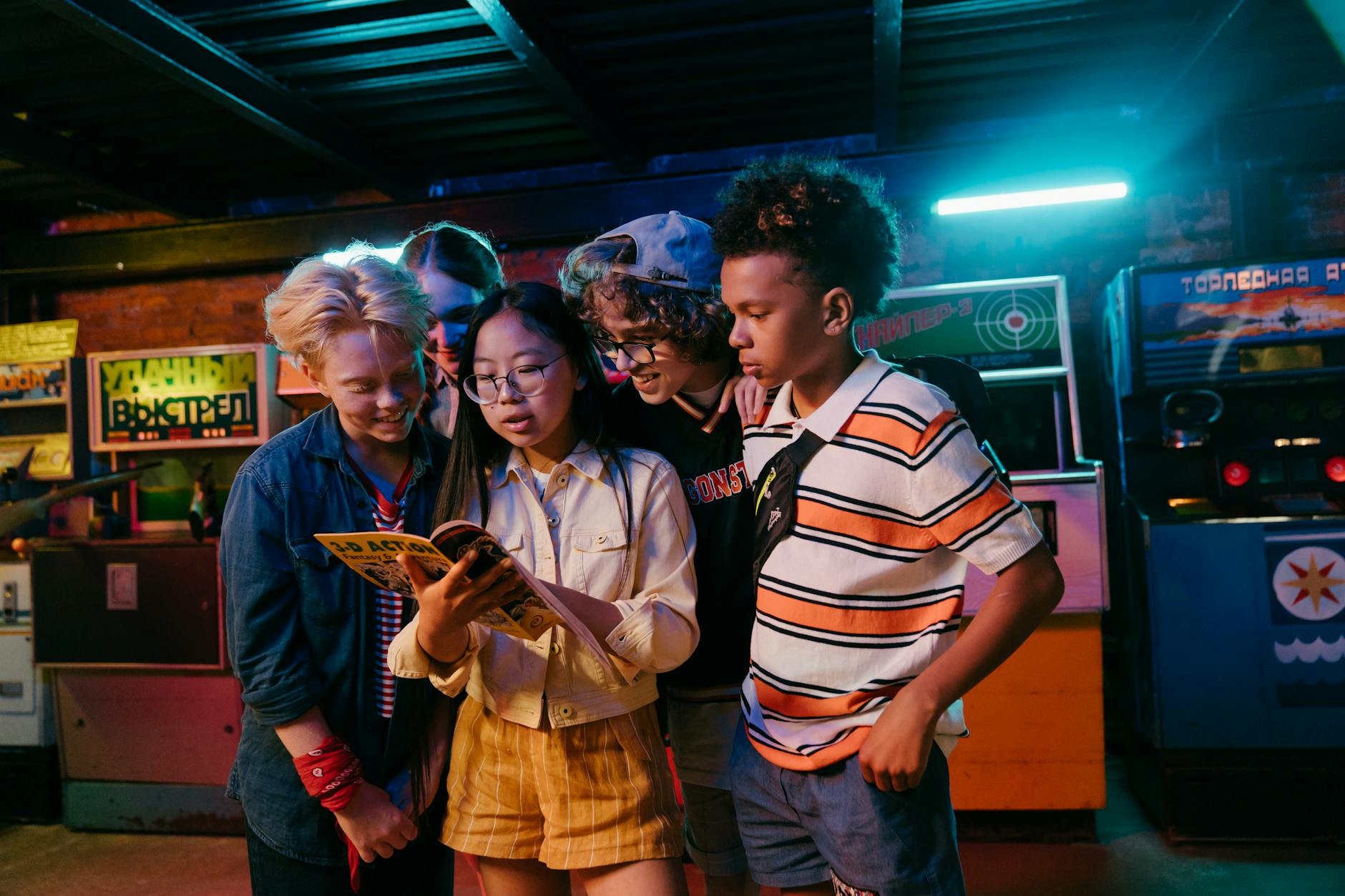 Group of diverse teenagers enjoying a retro arcade game, having fun indoors with friends.