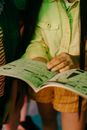 Woman in Green Button Up Shirt Holding Newspaper