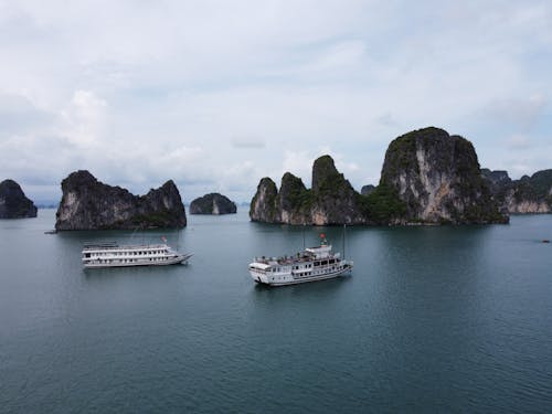 Ships floating near rocky cliffs