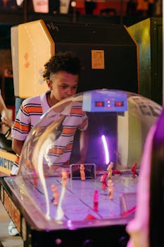 A teenager enjoying a game of dome hockey at an arcade, capturing a nostalgic and playful moment indoors.