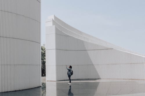 Man Taking a Photo of a Concrete Building 