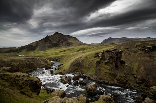 Creek on a Green Mountain Under Cloudy Sky