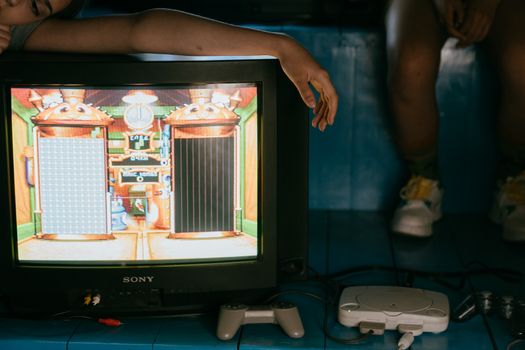 Crop unrecognizable female on modern monitor with video game on screen near ethnic partner