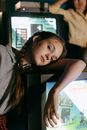 光线昏暗、游戏背景模糊的房间里，扎着辫子的少女靠在复古电视上