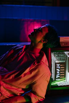 A teenager leans against a vintage arcade machine under colorful neon lights, evoking an 80s vibe.