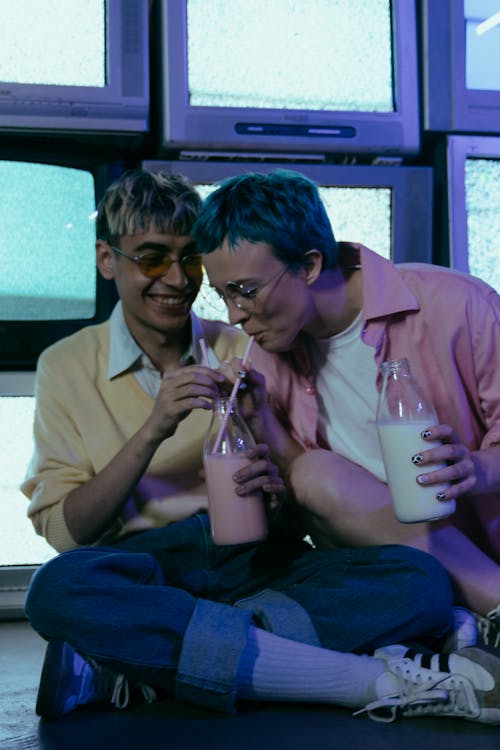 Man and Woman Sitting on Chair Holding Drinking Glasses