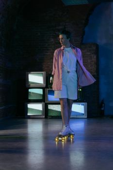 Teen skating indoors at night with retro TVs displaying static, creating a vintage vibes.