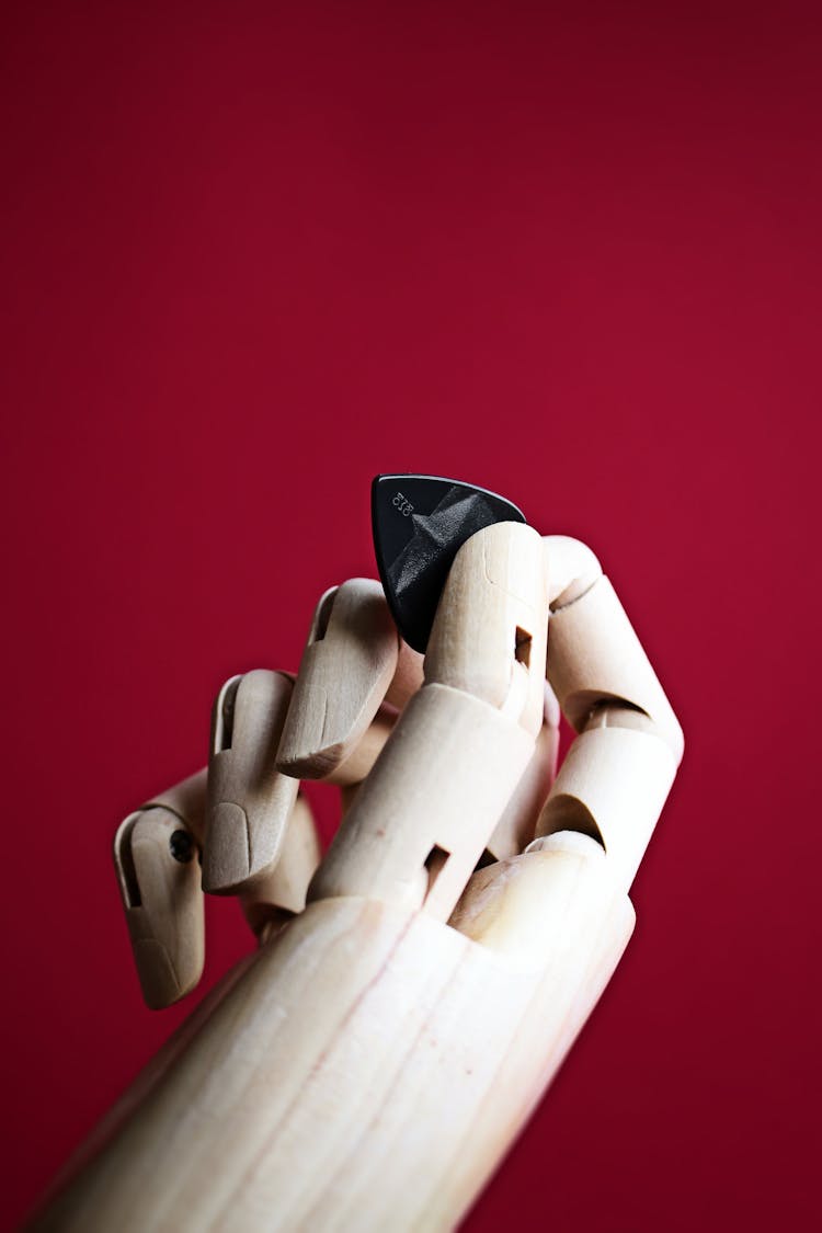 Wooden Prosthetic Hand Holding A Guitar Pick