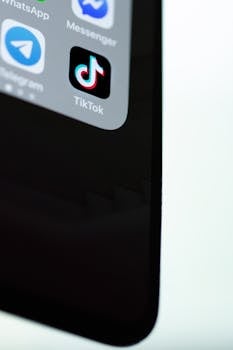 Detailed view of TikTok app icon on a modern smartphone screen, minimalist background.