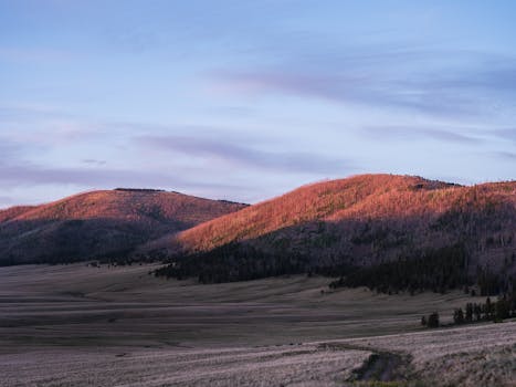 Breathtaking view of New Mexico hills with vibrant sunrise lighting the landscape.