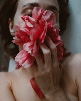 一位手持鲜艳牡丹花的女子肖像，营造出宁静而艺术的氛围