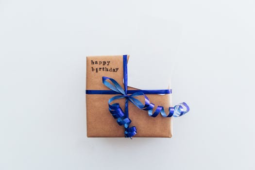 Top view of a brown gift box with blue ribbon and happy birthday tag.