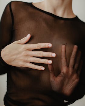 双手按压透明黑色面料的特写，突出纹理与形态