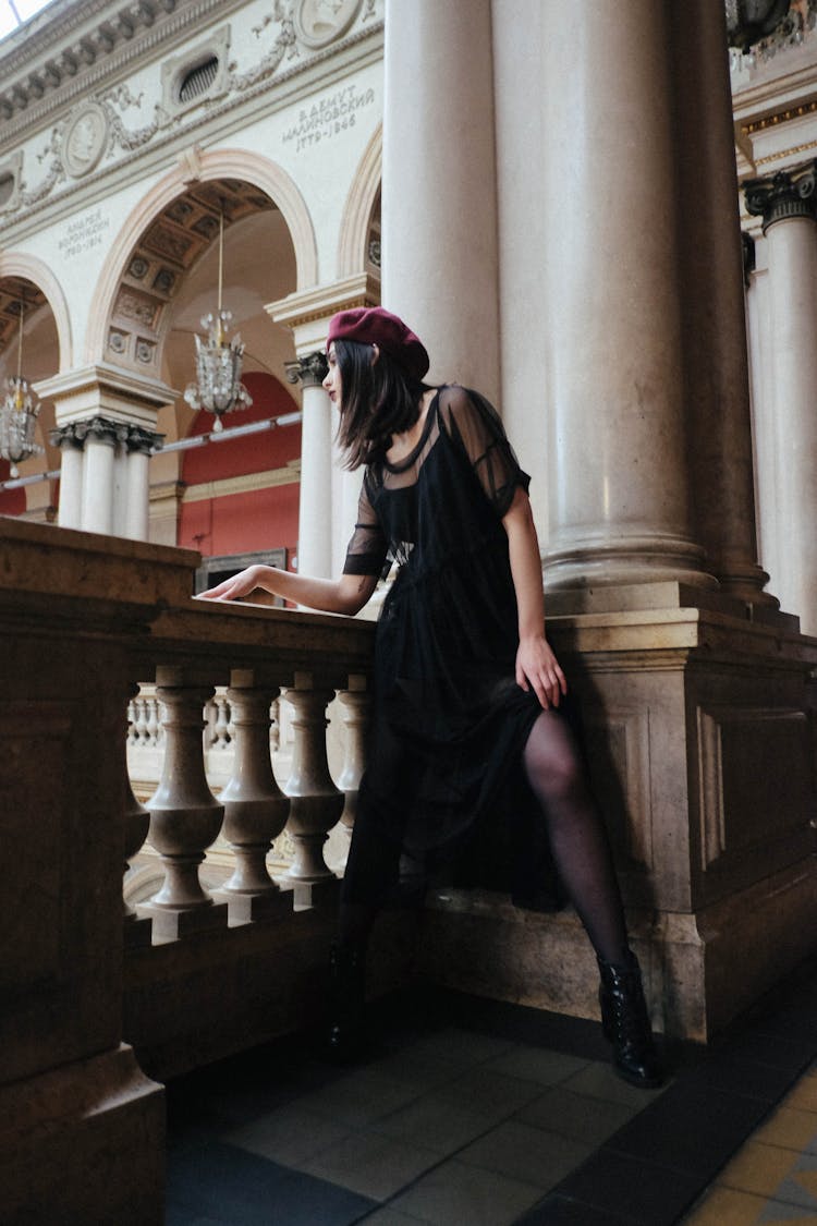 Sensual Trendy Woman Near Old Fence In Museum