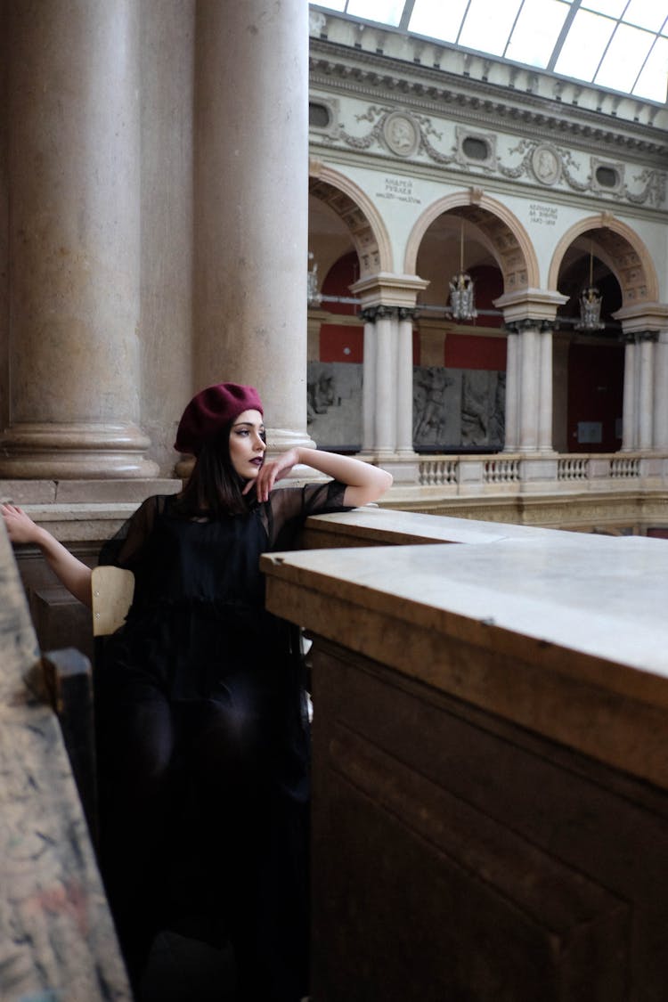 Contemplative Stylish Woman Near Masonry Fence In Aged Building