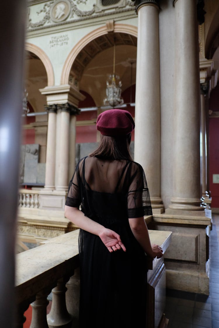 Faceless Woman In Stylish Beret Near Fence In Old Building