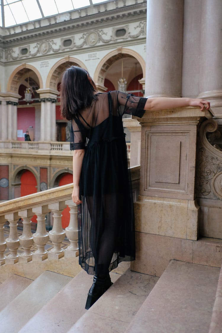 Unrecognizable Woman In Stylish Apparel On Stairs In Aged Building