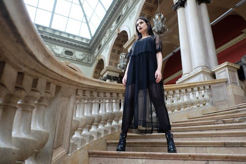 Free Stylish model in black wear on staircase in masonry building Stock Photo