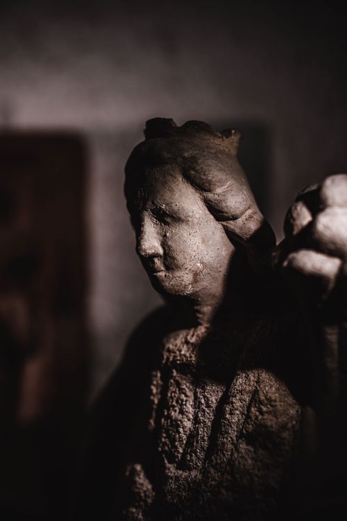 Free Close-up of a moody stone sculpture in shadowy lighting, evoking a vintage feel. Stock Photo