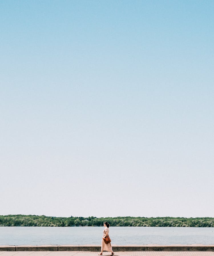 A Woman Walking Beside A Lake 