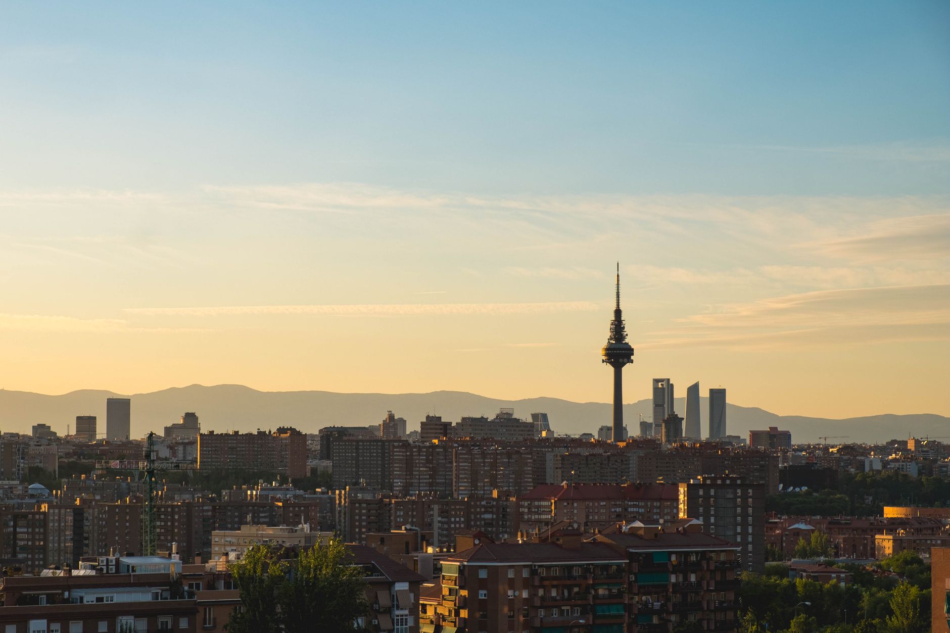A beautiful sunset over Madrid's skyline featuring Torre España and urban architecture.