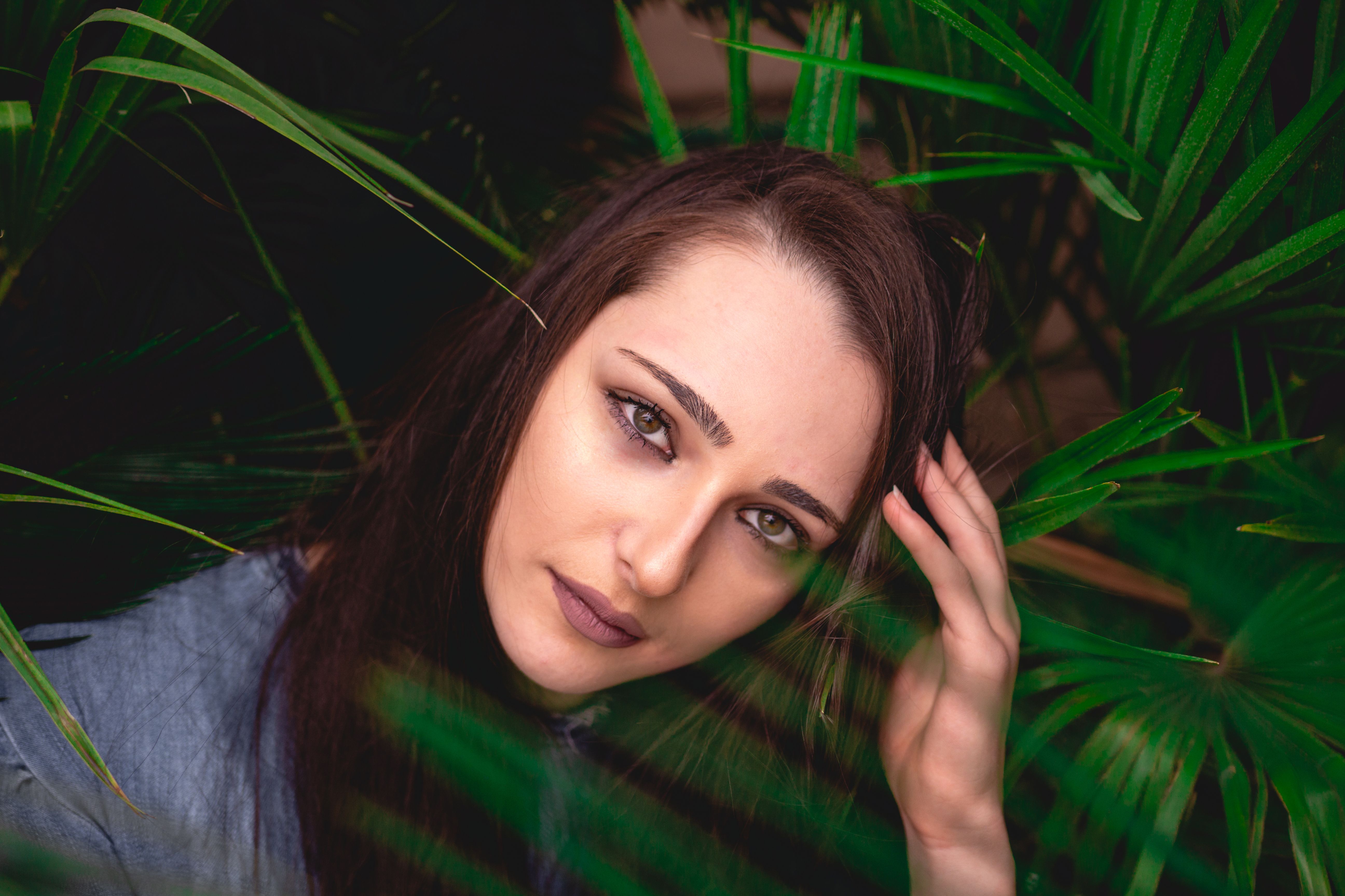 一位被户外充满活力的绿叶包围的女人的特写肖像