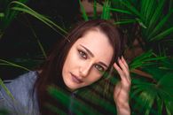 一位被户外充满活力的绿叶包围的女人的特写肖像