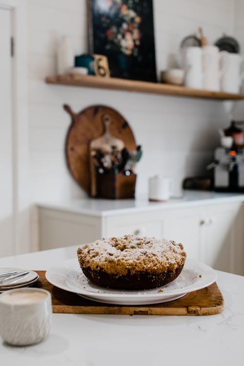 Fresh homemade cake placed on plate in light kitchen in apartment with light interior in daytime