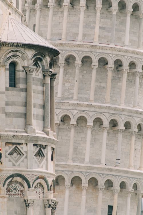 Free Exterior of aged stone cathedral with columns and carve details and leaning tower with pillars Stock Photo