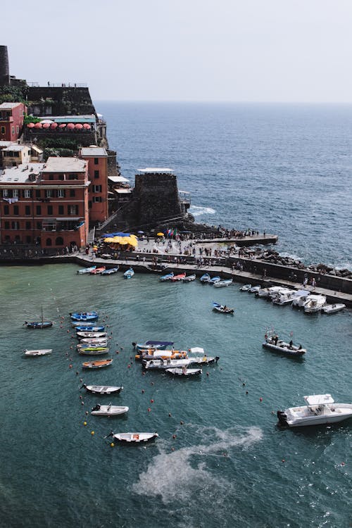 From above of coastal town with sailboats floating on rippling sea water in harbor