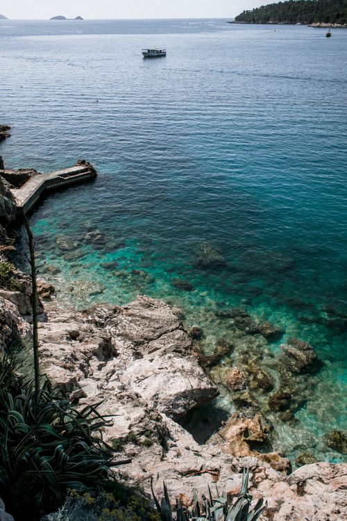 Free From above of rough stony shore of sea with rippling turquoise pure water Stock Photo