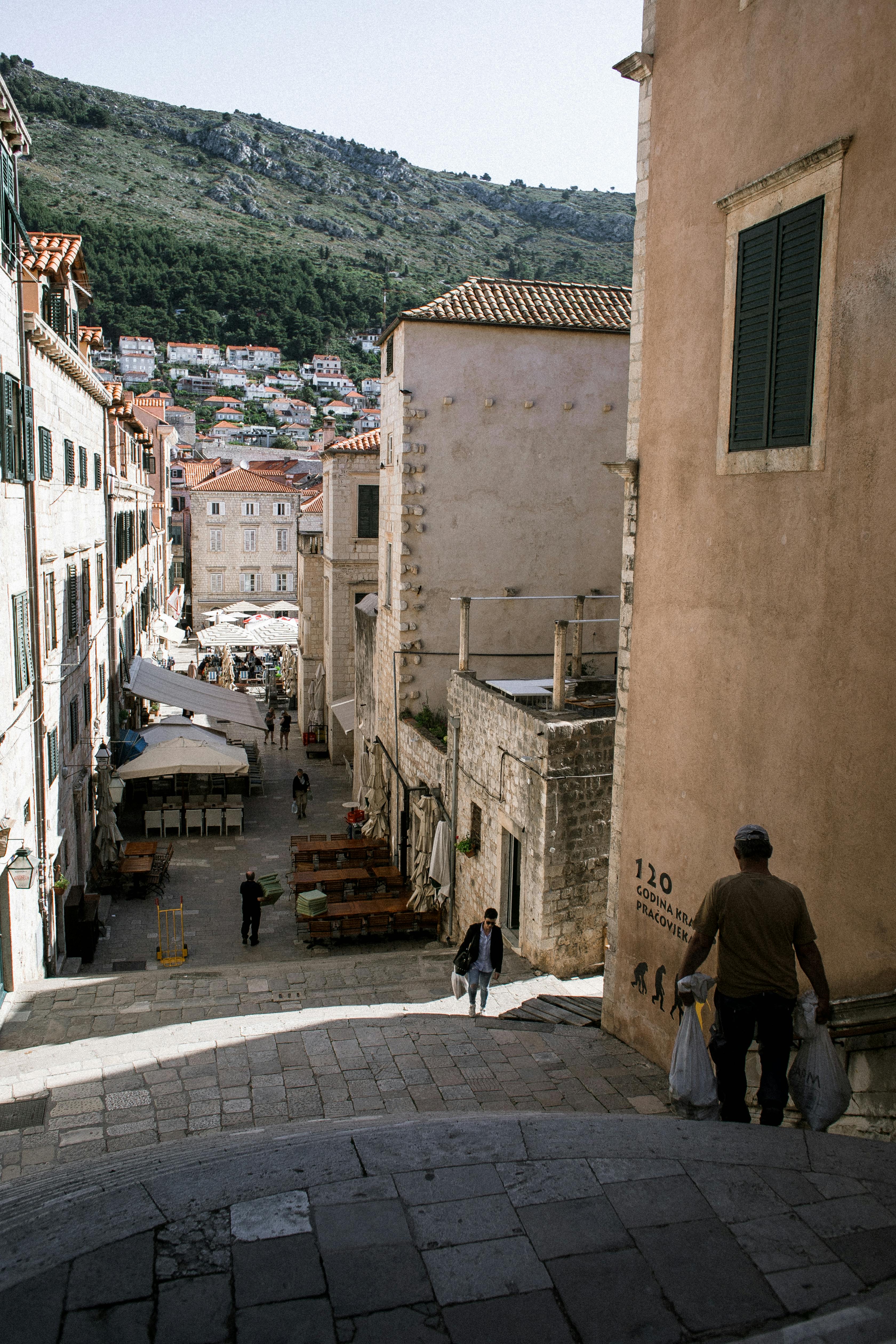 people walking along narrow street in town