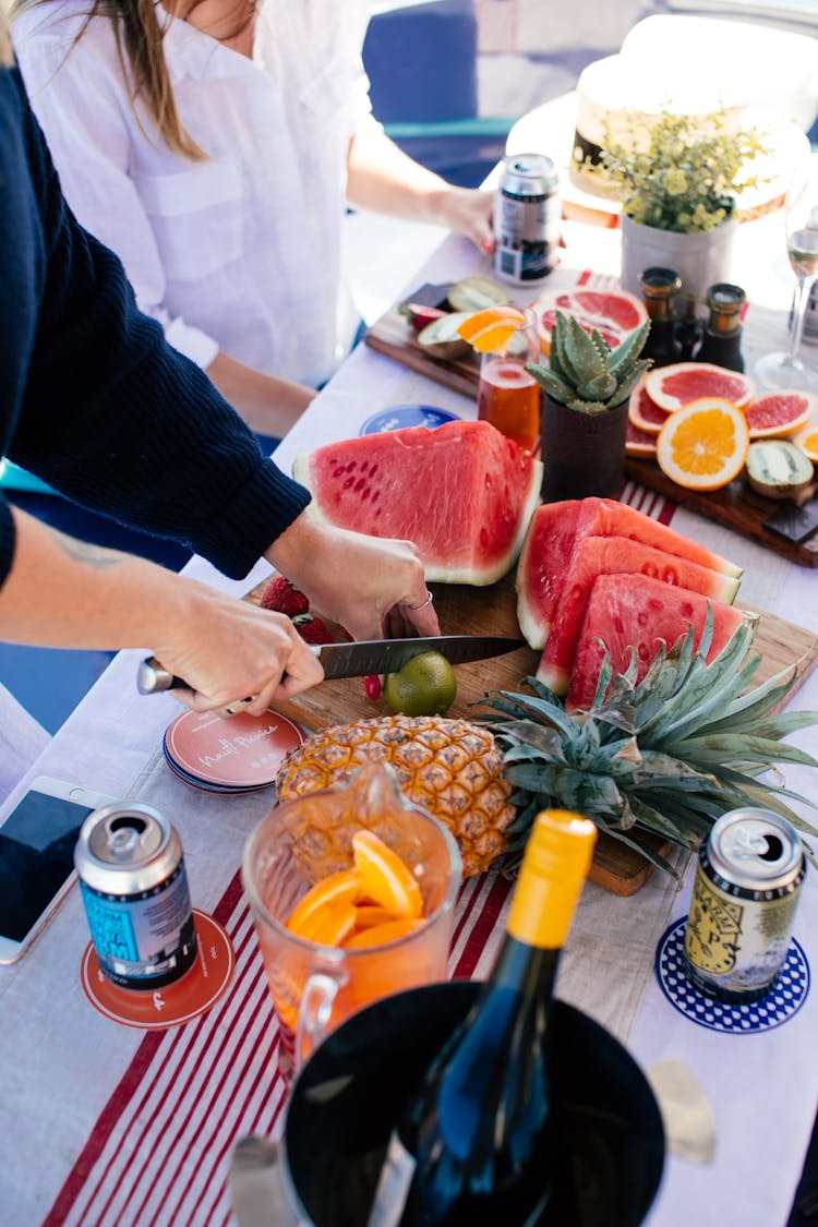 Crop Person Cutting Fruits On Table