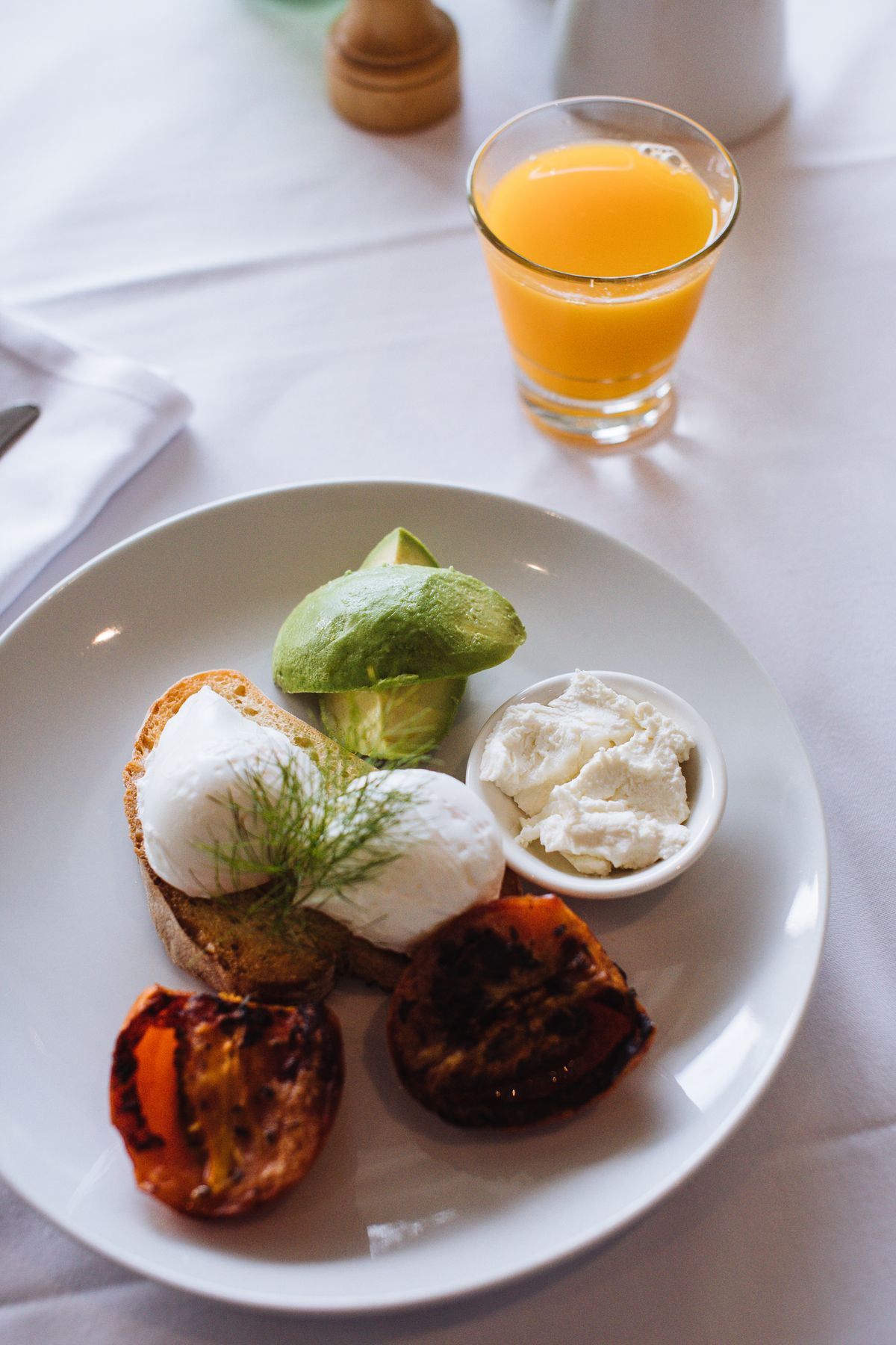Breakfast with eggs, avocado, tomatoes and orange juice