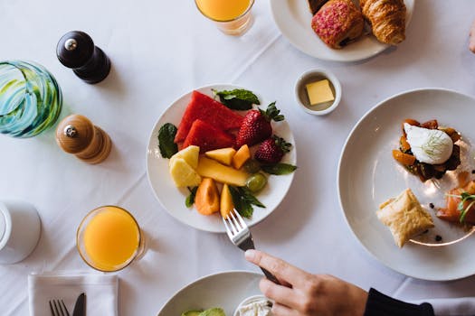 Overhead shot of a healthy breakfast with fruit, pastries, and juice.