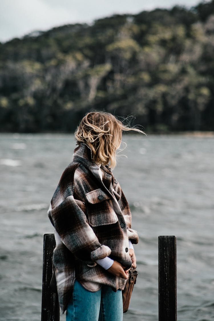 Woman In Warm Jacket Against River