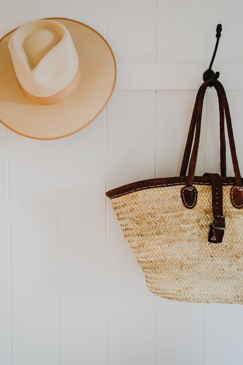 Free Stylish hat and bag hanging on coat hooks in entrance hall on white wall Stock Photo
