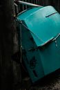 Small old shabby green row boat upside down placed near aged wooden construction