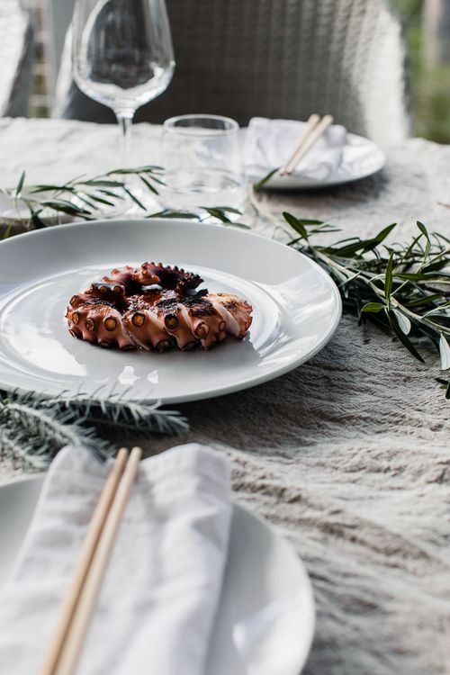 Free Plate with tasty grilled octopus tentacle placed on table prepared for romantic date Stock Photo
