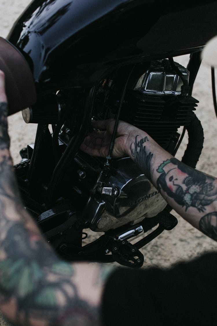 Crop Man Checking Motor Of Bike